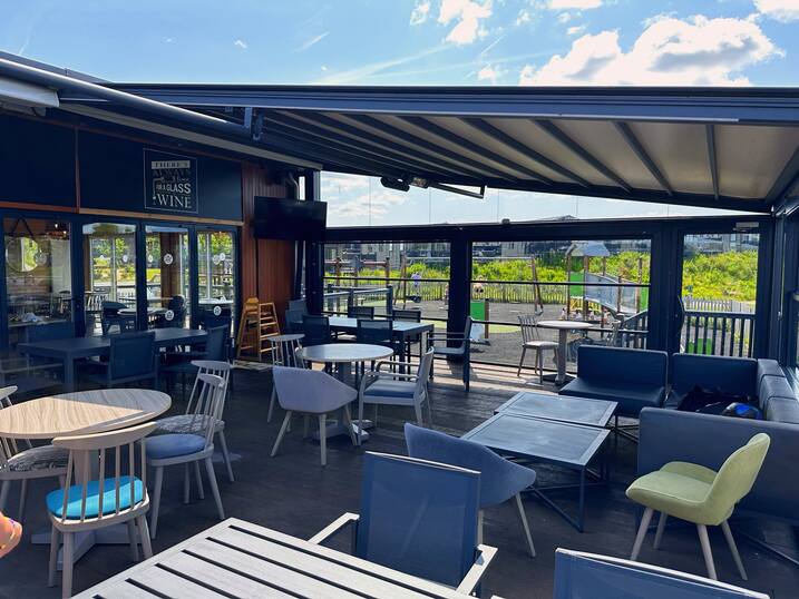 Ample outdoor seating at the bar & restaurant, with retractable cover.