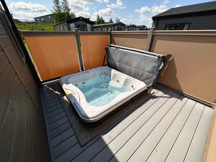 On the decking viewing the outdoor hot tub.